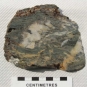 Image couleur d’une roche grise avec veines de couleur or, blanc et orange