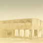 Photographie noir et blanc d’un ancien bâtiment en bois de deux étages