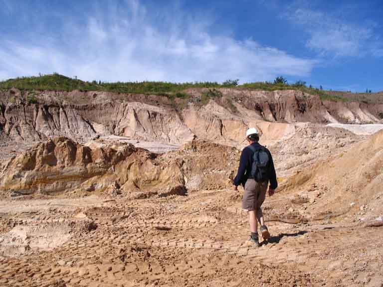 Photographie couleur d’un homme traversant une étendue de rochers blancs dans la carrière
