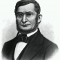 Black and white print of man in black suit, beard and glasses